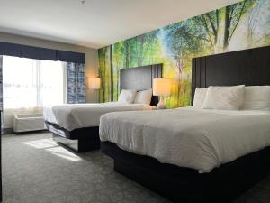ein Hotelzimmer mit 2 Betten und einem Gemälde an der Wand in der Unterkunft Casco Bay Inn in Freeport