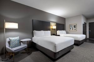 um quarto de hotel com duas camas e uma cadeira em Holiday Inn Carlsbad/San Diego, an IHG Hotel em Carlsbad