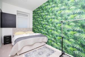 1 dormitorio con un mural verde y frondoso en la pared en Downtown Cozy Apartment, en Sarajevo