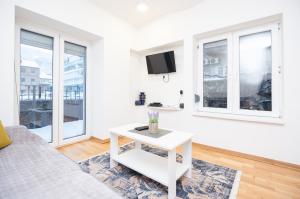 Sala de estar blanca con sofá y mesa en Downtown Cozy Apartment, en Sarajevo