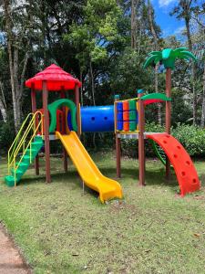 um parque infantil com escorregas coloridos num parque em Flat Pedra Azul em Aracê