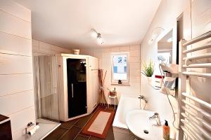 une salle de bain blanche avec un lavabo et des toilettes dans l'établissement Seeurlaub Müritz - Haus Auszeit mit Sauna, à Röbel