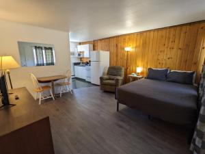 a bedroom with a bed and a table and a kitchen at Deerview Lodge & Cabins - Princeton BC in Princeton