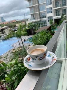 eine Tasse Kaffee auf einem Teller auf einem Balkon in der Unterkunft Cozy condo unit at The Palladium in Iloilo City