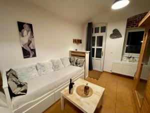 uma sala de estar com um sofá branco e uma mesa em Ubytování v soukromí Bělčice em Bělčice