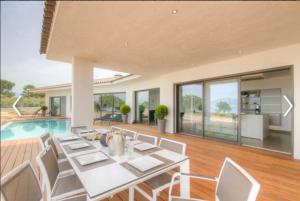 comedor con mesa, sillas y piscina en Villa HAPPY DAYS, en Pietrosella