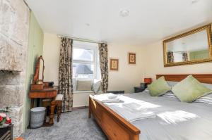 a bedroom with a bed with a mirror and a window at Duke’s Cottage in Portland