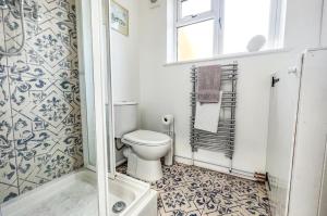 a bathroom with a toilet and a shower at Duke’s Cottage in Portland