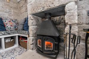 a stone fireplace with a stove in a room at Duke’s Cottage in Portland