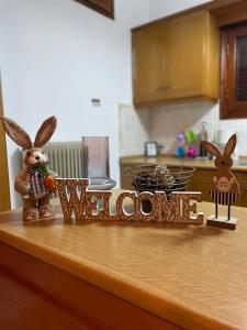 a kitchen counter with a welcome sign and rabbits on it at My Sweet Home in Tríkala