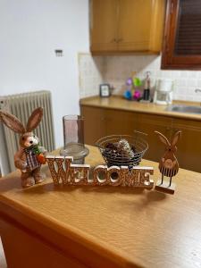 a kitchen counter with rabbits and a welcome sign on it at My Sweet Home in Tríkala