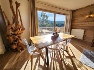 a wooden table and chairs in a room with a window at Gréolières Les Neiges in Gréolières