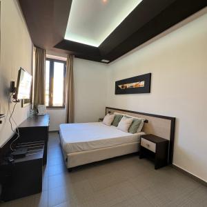 1 dormitorio con 1 cama y TV en Boteco B&B en Bacoli