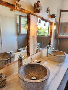 uma casa de banho com 2 lavatórios e um espelho grande em Gréolières Les Neiges em Gréolières