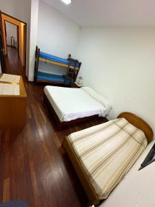 2 camas en una habitación con suelo de madera en Casa familiar Nivel Superior en San Fernando del Valle de Catamarca
