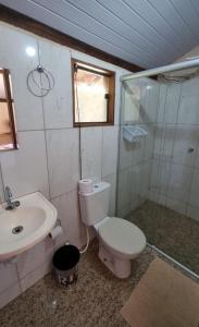 a bathroom with a toilet and a sink at Pousada Portal da Serra - Chalés in Carrancas