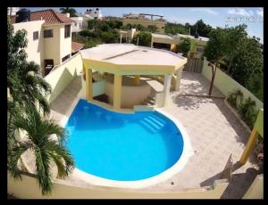 uma piscina com um gazebo numa casa em Villa Victoria em La Romana