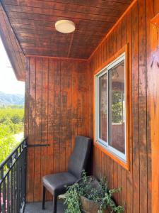 einen Stuhl auf einer Veranda mit einem Fenster in der Unterkunft Hostal Renacer in Santa Cruz