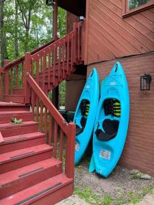 dois caiaques azuis estacionados ao lado de um edifício com escadas em Poconos Chalet -Kayaks- HotTub-Karaoke-Lake em East Stroudsburg