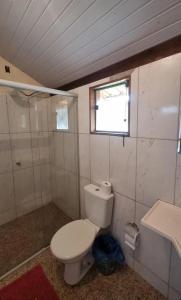 a small bathroom with a toilet and a window at Pousada Portal da Serra - Chalés in Carrancas