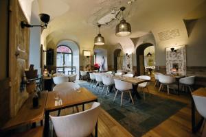 a restaurant with white chairs and tables in a room at Hotel Zenit Budapest Palace in Budapest