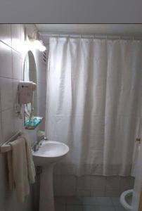 baño con cortina de ducha blanca y lavamanos en Alquileres Temporarios Darío en Maipú