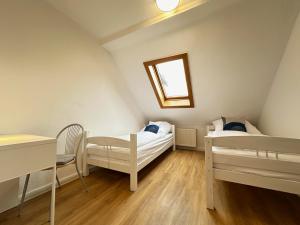a bedroom with two beds and a table and a window at Cleo Apartments in Kassel