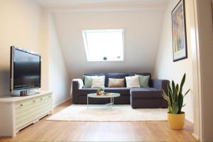 sala de estar con sofá azul y TV en Cleo Apartments en Kassel