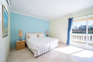 een witte slaapkamer met een bed en een raam bij Casa Ferrel - Luxury 9 Bedroom Villa with Indoor & Outdoor Pools in Lagos +36 foto's