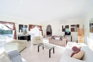 een woonkamer met een bank en een tafel bij Casa Ferrel - Luxury 9 Bedroom Villa with Indoor & Outdoor Pools in Lagos