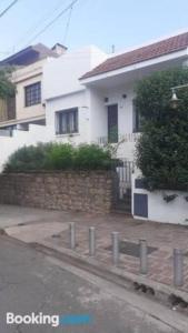 ein weißes Haus mit einem Zaun davor in der Unterkunft Casa Estilo Mediterráneo Jujuy in San Salvador de Jujuy