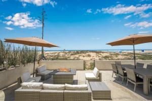 a patio with tables and chairs and umbrellas at 6 Bedroom Remodeled Home on the Oceanfront in Newport Beach