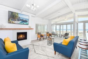 a living room with blue chairs and a fireplace at 6 Bedroom Remodeled Home on the Oceanfront in Newport Beach