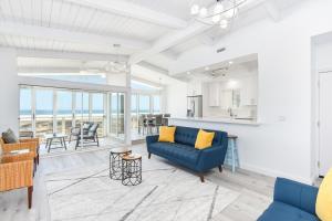 a living room with a blue couch and a table at 6 Bedroom Remodeled Home on the Oceanfront in Newport Beach