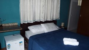 ein Schlafzimmer mit einem Bett mit zwei Handtüchern darauf in der Unterkunft Pousada Quintal do Mar in Ubatuba