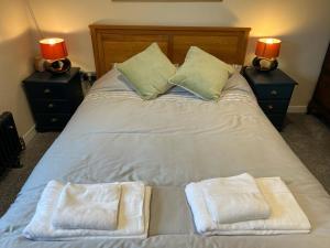 a bed with two towels on it with two lamps at Duke’s Cottage in Portland +4 photos