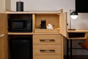 a kitchen with a cupboard with a microwave at The Bayshore Hotel San Francisco Airport - Burlingame in Burlingame