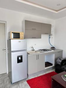 a kitchen with white appliances and a red rug at Dyar Amina in Midoun