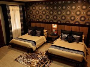 a bedroom with two beds and a wall at 3BR Private Bungalow Duplicate in Davao City