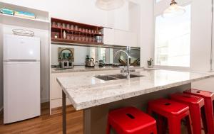 a kitchen with a sink and red stools at 3BR Private Bungalow Duplicate in Davao City
