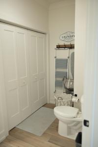 a white bathroom with a toilet and a closet at New Modern Style Townhome in Sevierville