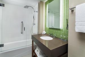 uma casa de banho com um lavatório e um chuveiro com um espelho. em The Westin San Diego Gaslamp Quarter em San Diego