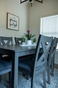 a dining room table and chairs with plants on it at New Modern Style Townhome in Sevierville