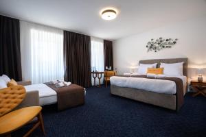 a hotel room with two beds and a table at Hotel Šumava in Železná Ruda