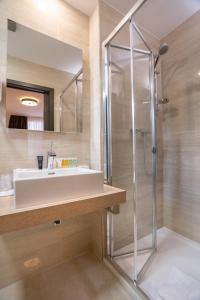 a bathroom with a sink and a shower at Hotel Šumava in Železná Ruda