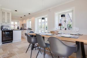 a kitchen and dining room with a table and chairs at Hues Kjerte in Wenningstedt