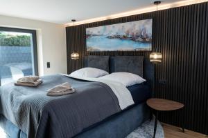 Wellness House Oase Spa mit Whirlpool في تيميندورفير ستراند: غرفة نوم بسرير ازرق مع لوحة على الحائط