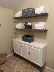 een badkamer met witte handdoeken op een plank bij Theos Cottage Niagara in Lewiston