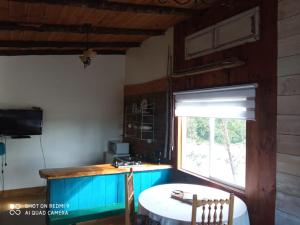 cocina con mesa blanca y ventana en Cabañas Juan Jose, en Piruquina