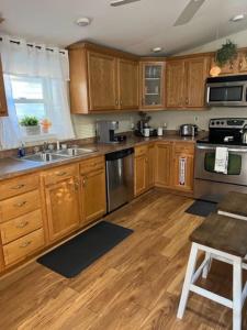 eine Küche mit Holzschränken und Küchengeräten aus Edelstahl in der Unterkunft Theos Cottage Niagara in Lewiston